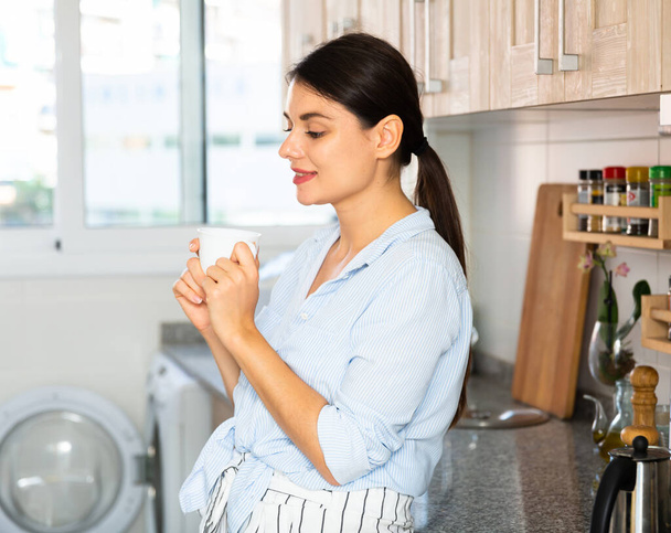 Portrait of happy brunette woman in kitchen - Foto, Imagen