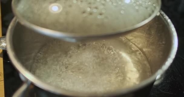 Forró víz egy rozsdamentes acél csészealjban. Nyitott üvegfedél. Közelkép, felülnézet. Közelkép, absztrakció. Kiváló minőségű 4k felvételek - Felvétel, videó