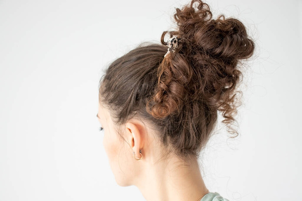 Un pelo rizado de las mujeres se recoge en un montón - Foto, imagen