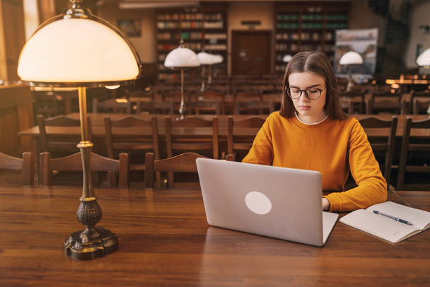 Ориентированная девушка с помощью ноутбука, студент учится в городской библиотеке, цифровое образование, подростки печатают на компьютере просмотра веб-браузера, блоггер социальных сетей. - Фото, изображение