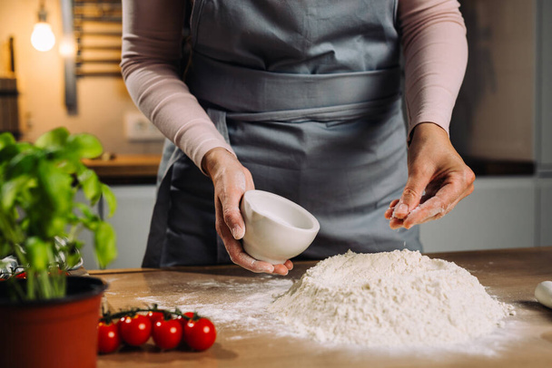 woman adding yeast to flour - Фото, зображення