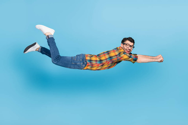Full size profile photo of overjoyed cheerful man raise arms flying levitate isolated on blue color background. - Foto, afbeelding