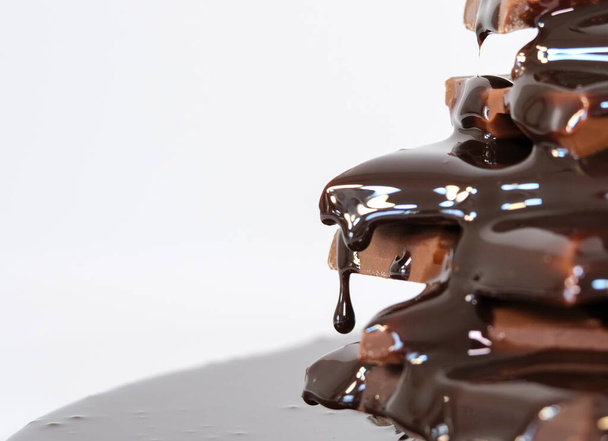 salsa de chocolate que fluye sobre trozos de chocolate - Foto, imagen
