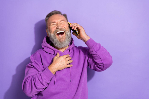 Photo of aged experienced attractive senior man hold phone talking laughter joke good mood empty space isolated on purple color background. - Φωτογραφία, εικόνα