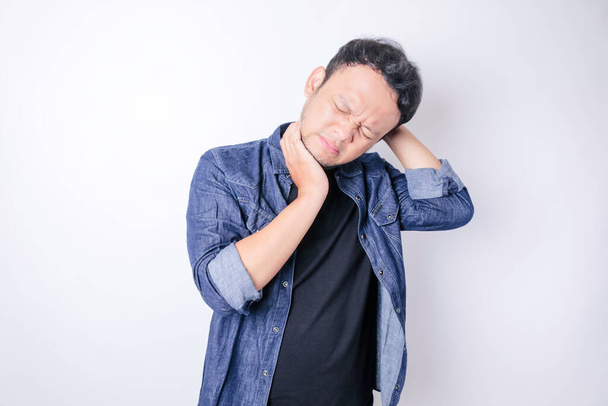 Asian handsome man suffering from headache standing over isolated white background - Foto, Imagem