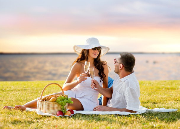 happy couple drinking champagne on picnic - 写真・画像