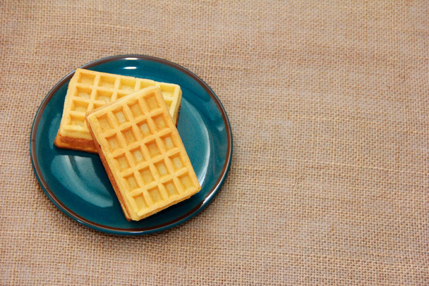 waffles belgas assados doces em uma placa de cerâmica azul e um fundo folgado - Foto, Imagem