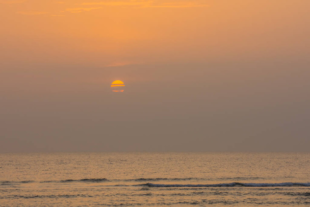 halb bedeckte Sonne bei Sonnenaufgang am Meer in Ägypten - Foto, Bild
