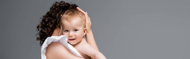 Femme étreignant fille bébé souriante isolée sur gris, bannière  - Photo, image