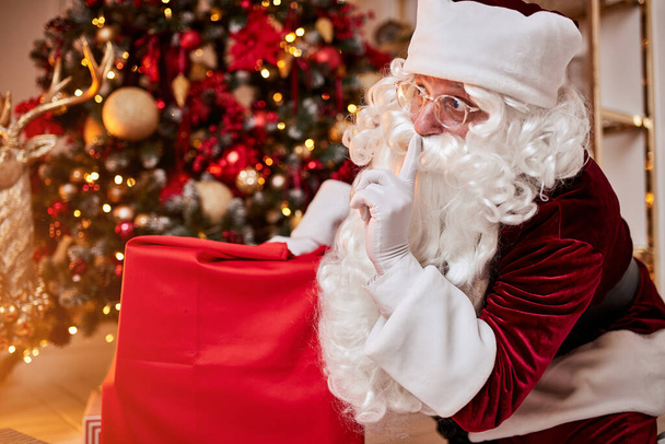Święty Mikołaj z dużą czerwoną torbą prezentów pędzi przynieść prezent dla dzieci. Nowy rok i Wesołych Świąt, koncepcja szczęśliwych świąt - Zdjęcie, obraz