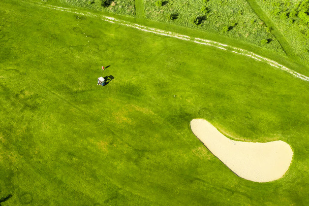 Golf course with sand bunker and green grass, aerial view. - Photo, image