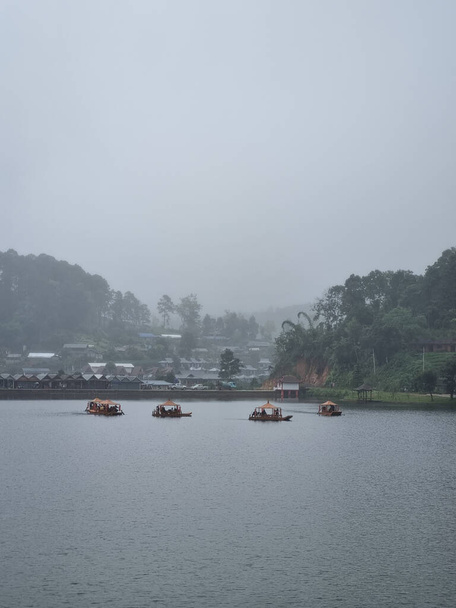 Łodzie w jeziorze na Ban Rak Thai, chińska osada w Mae Hong Son, Tajlandia strzał pionowy - Zdjęcie, obraz