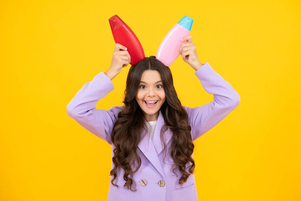 Child with shampoo conditioner. Daily cosmetic care. Teenager kid 12, 13, 14 years old hold bottle of hair and skin care. Beauty health and cosmetics. Happy teenager - Φωτογραφία, εικόνα
