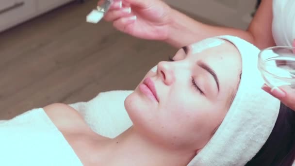 Zbliżenie na kobietę leczoną maską glinianą. Kosmetologia i spa. Wysokiej jakości materiał 4k - Materiał filmowy, wideo