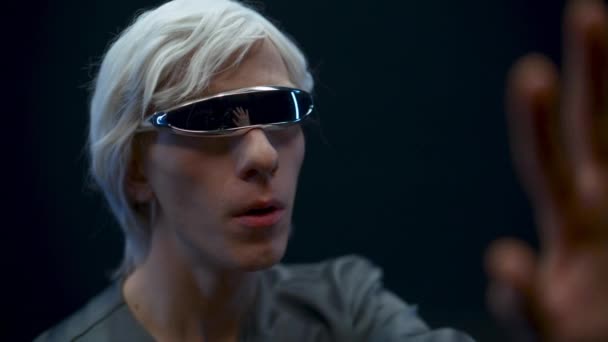 Наркоман - гравець, який досліджує світ віртуальної реальності. Емоційна шокуюча людина з VR-хедсетом занурена в 3D чорний фон. Хлопець захоплюється розширеним простором, граючи у відеоігри. Метаверна технологія  - Кадри, відео