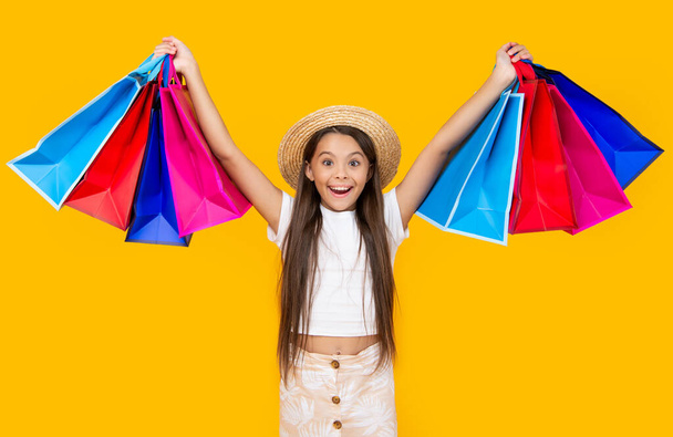 amazed teen girl with shopping bags on yellow background. - Foto, Imagem
