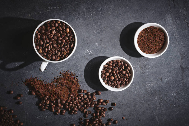 White cup of freshly brewed roasted coffee beans on gray background - Foto, immagini
