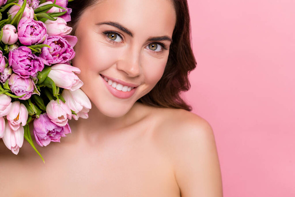 Fotografie rozkošné lesklé mladé ženy nahé ramena drží květiny květ prázdný prostor izolované růžové barvy pozadí. - Fotografie, Obrázek