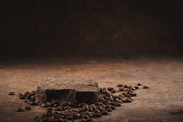 Roasted coffee beans on stone pedestal brown background - Foto, Imagem