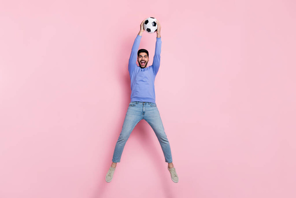 Full length photo of strong funny guy dressed blue pullover jumping high catching ball isolated pink color background. - Φωτογραφία, εικόνα