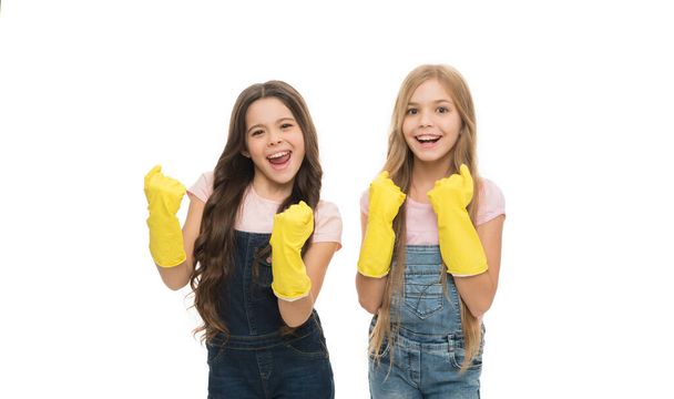 Kids cleaning together. Girls with yellow rubber protective gloves ready for cleaning. Household duties. Little helper. Girls cute kids love cleaning around. Keep it clean. Protect sensitive skin. - Foto, Imagem