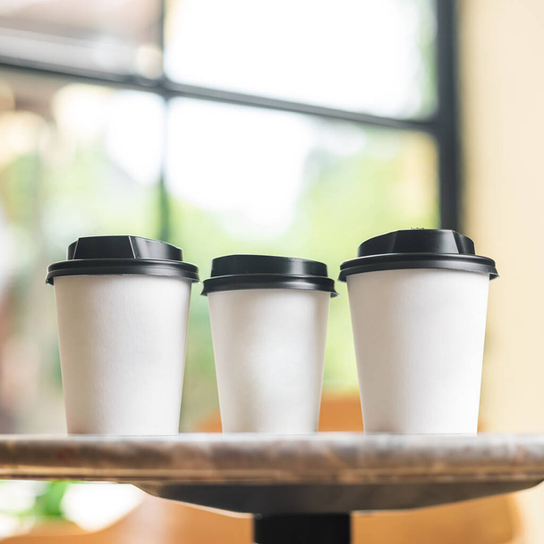 Attrappe. Kaffeetasse wegnehmen leeren leeren Kopierraum für Design. Papiertassen Kaffee auf grauem Stein Tischhintergrund. - Foto, Bild