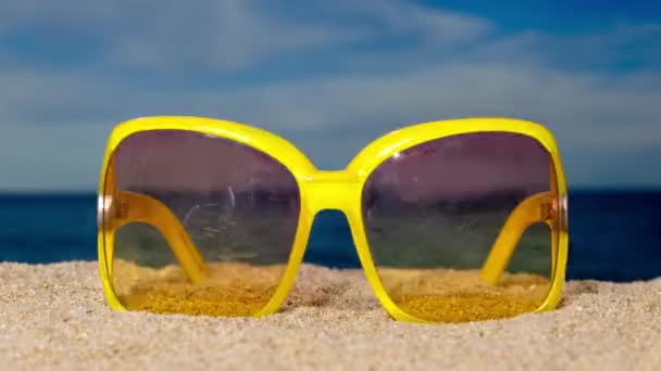 Μια σειρά από γυαλιά ηλίου στην παραλία με περαστικά σύννεφα  - Πλάνα, βίντεο