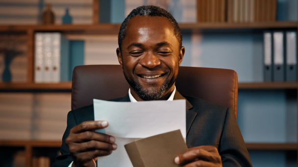 Successful businessman sits in office opening paper envelope reading letter with good news received bank loan approval profitable proposition happy man gets promotion career advance great opportunity - Foto, Bild