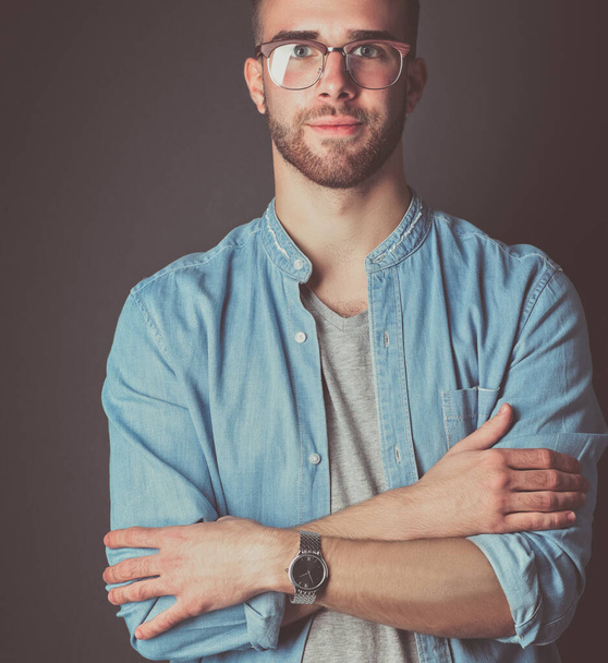 Portrait of a happy casual man standing isolated on a dark background. Handsome male posing - Фото, зображення
