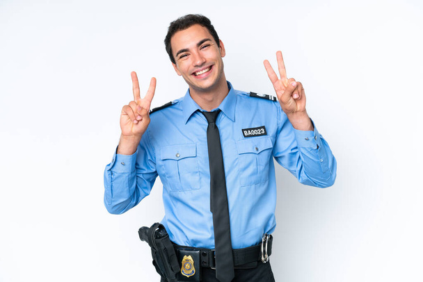 Junger kaukasischer Polizeimann auf weißem Hintergrund, der mit beiden Händen das Siegeszeichen zeigt - Foto, Bild