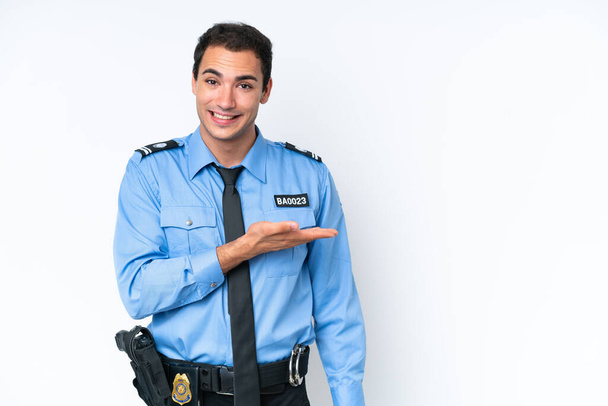 Junge kaukasische Polizei Mann isoliert auf weißem Hintergrund präsentiert eine Idee, während lächelnd in Richtung - Foto, Bild