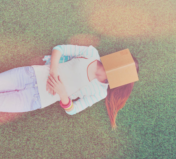 Beautiful young woman lying on the green grass. - Photo, image