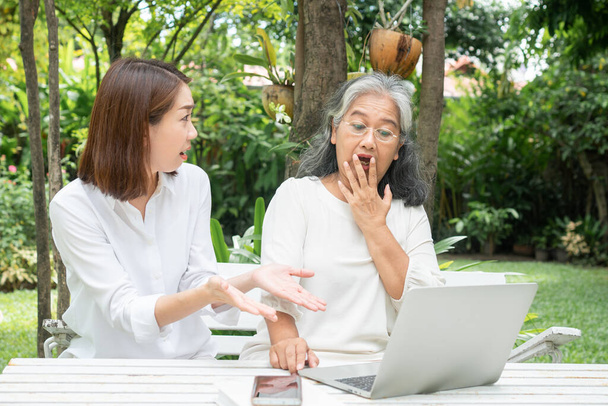 Aziatische dochter onderwijs oude oudere vrouw gebruik online Social media in computer laptop na pensionering. Begrip leertechnologie en aanpassing van ouderen - Foto, afbeelding