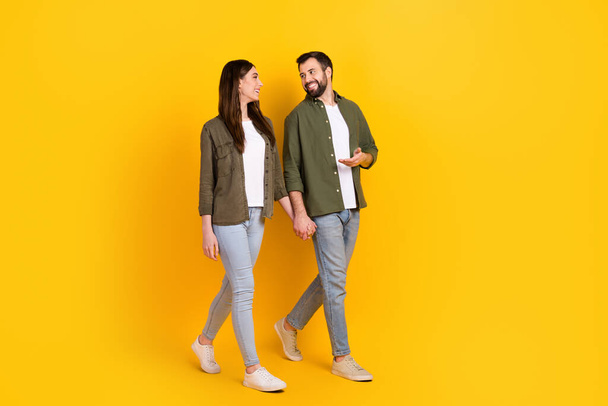 Full length body size view of attractive cheerful couple spending day talking going isolated over bright yellow color background. - Foto, Imagem