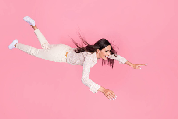 Full size photo of cheerful lady levitating in air flying ahead in her dreams isolated on pastel color background. - Foto, imagen