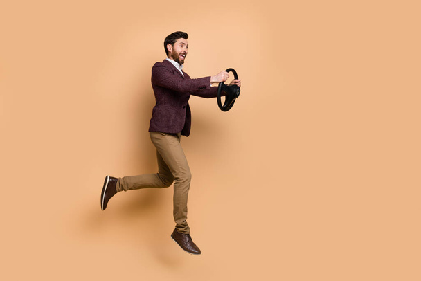Full size profile side photo of young businessman hurry rush to work driving car isolated on beige color background. - Φωτογραφία, εικόνα