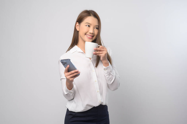 A Young asian woman using smartphone over white background, technology concept. 		 - Foto, Bild