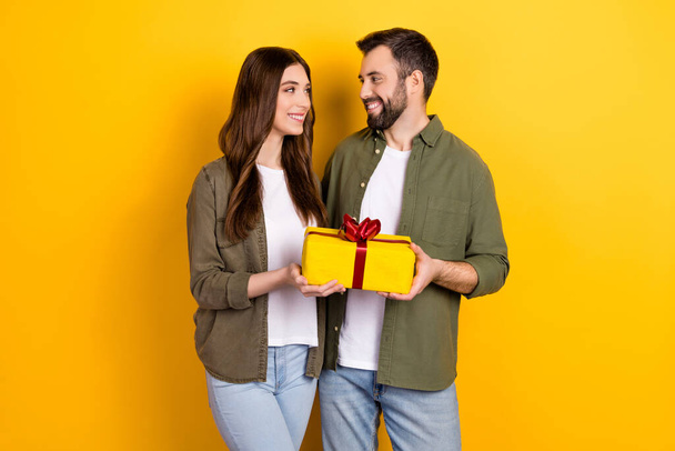 Photo of young lovely couple celebrate wedding anniversary give each other gifts isolated on yellow color background. - Photo, image