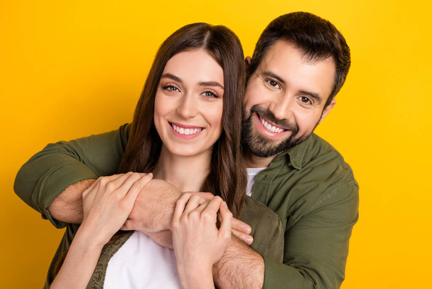 Photo of idyllic peaceful partners embrace toothy smile look camera isolated on yellow color background. - Zdjęcie, obraz