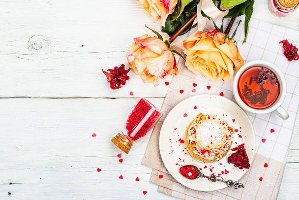 The concept of romantic tea. French Shu cake, hibiscus tea, bouquet of roses, festive decor. Valentine's Day concept, Women's Day March 8, Wedding. White boards background, top view - Fotoğraf, Görsel