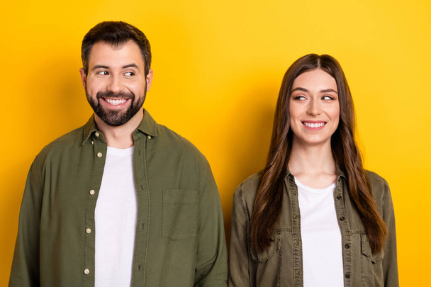 Portrait of positive friendly people toothy smile look each other isolated on yellow color background. - Фото, зображення