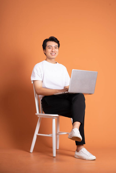 man sitting on chair  isolated on orange background - Foto, Imagen