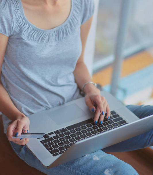 Young beautiful woman using a laptop computer at home. Young beautiful woman - Фото, изображение