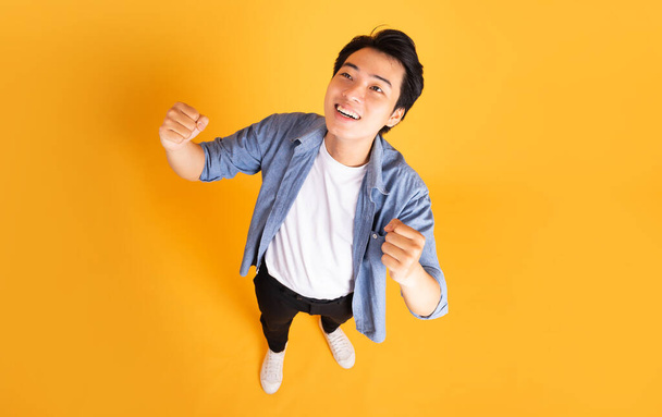 image of asian man posing on a yellow background - Фото, изображение