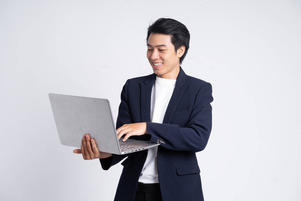 Jonge zakenman in een pak poseren op een witte achtergrond - Foto, afbeelding