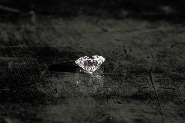 Ronde geslepen diamanten edelsteen op zwart hout - Foto, afbeelding