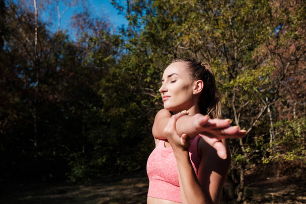 Sopiva nuori nainen venyttelee ja harrastaa liikuntaa Lontoon lähellä sijaitsevassa metsässä. Terveyden ja luonnon käsite. - Valokuva, kuva