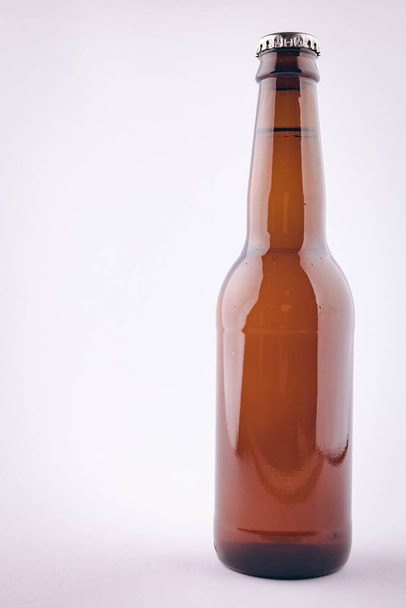 Image of brown glass full lager beer bottle with crown cap, with copy space on white background. Drinking alcohol, refreshment and lager day celebration concept. - Φωτογραφία, εικόνα