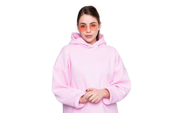 Serious young woman in casual pink hoodie and glasses isolated on white. - Фото, изображение
