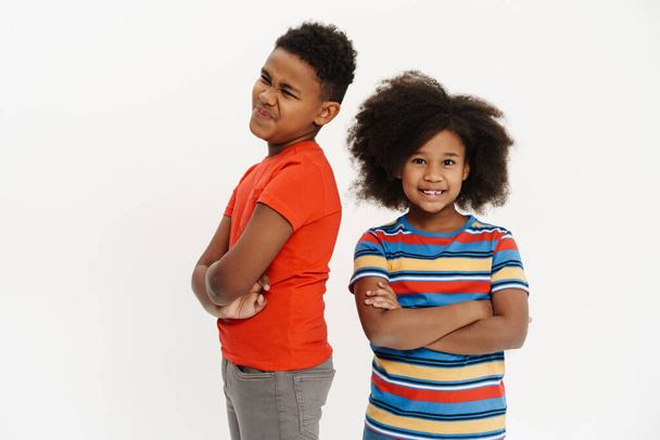 Black boy and girl smiling while grimacing at camera isolated over white background - Foto, Imagen
